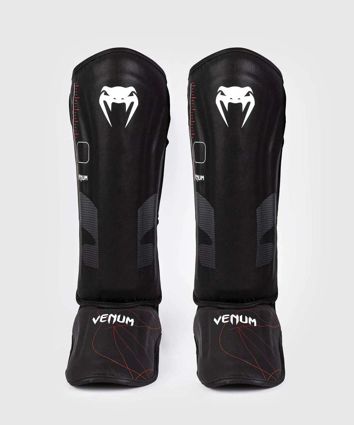 Black and red Venum Tactical XT shin and foot guards with multi-density foam and velcro straps for shock absorption and secure fit.
