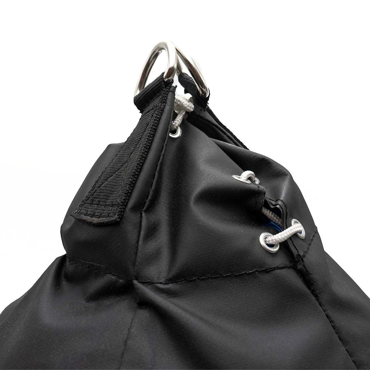 Close-up of the top part of the black Sac de frappe Uppercut FUJIMAE punching bag showing reinforced stitching, metal rings, and durable synthetic leather material.