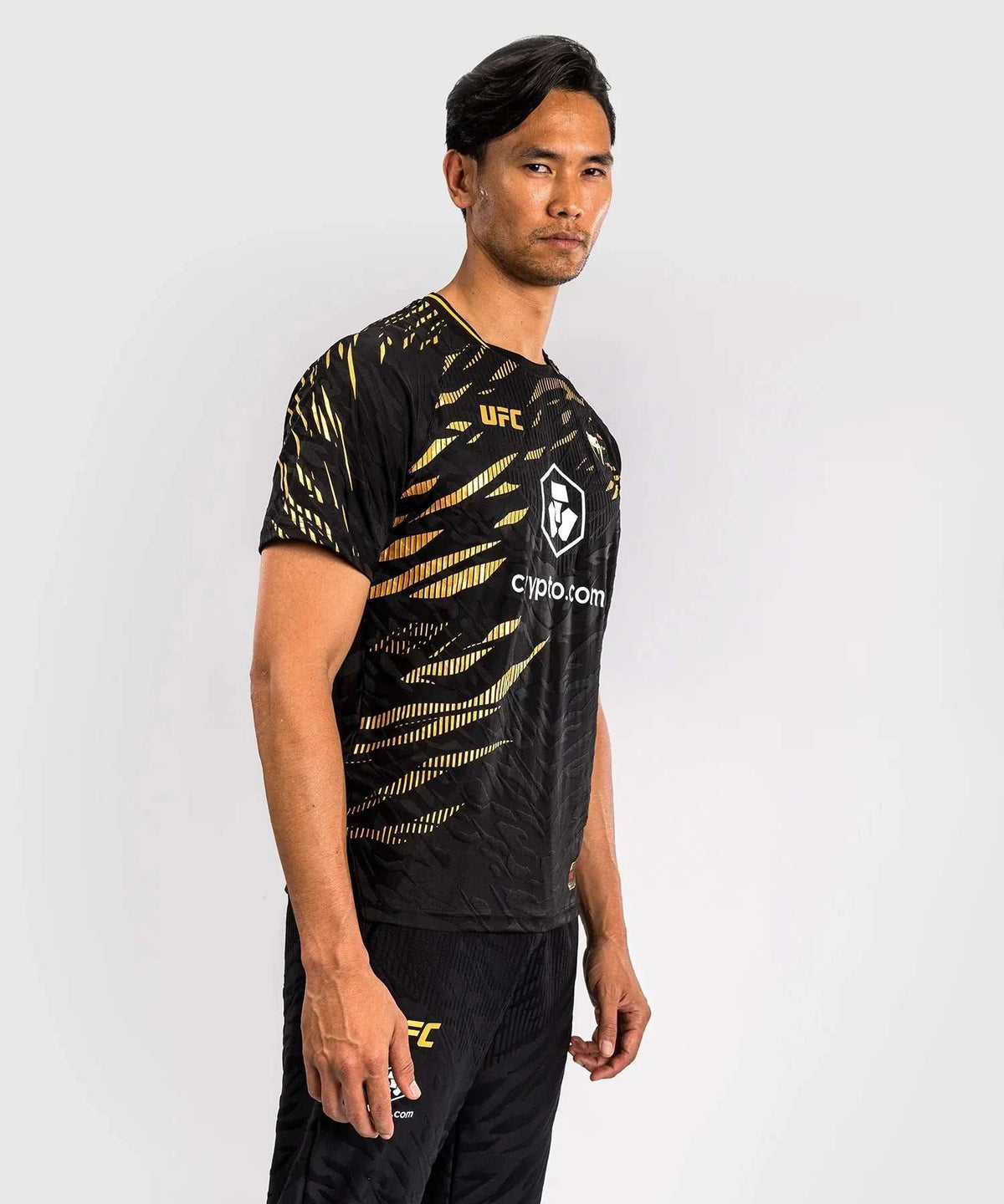 Men wearing black and gold UFC Fusion par Venum Dry-Tech performance T-shirt with short sleeves and breathable fabric