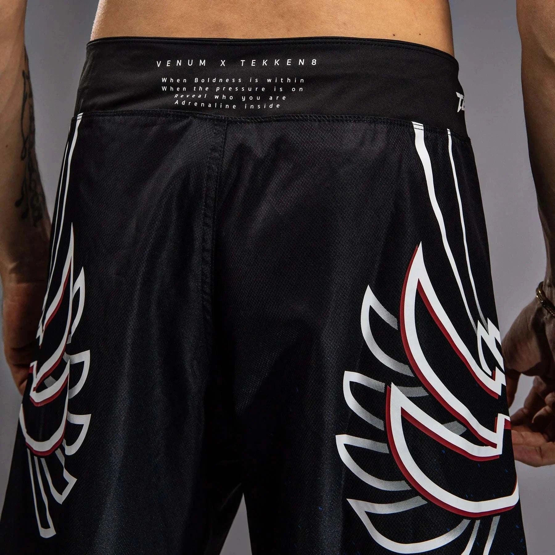 Short de combat Venum x Tekken 8 Jin Kazama bleu noir blanc, design ailes d’ange et fermeture sécurisé.