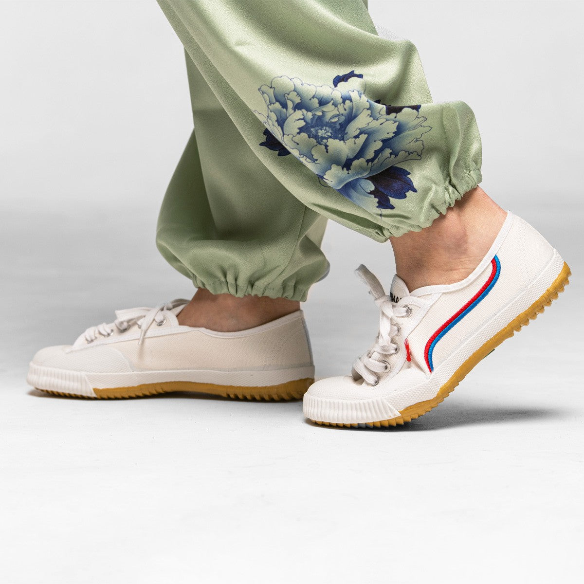 Chaussures Shaolin FUJIMAE blanches portées avec un pantalon de Tai Chi vert