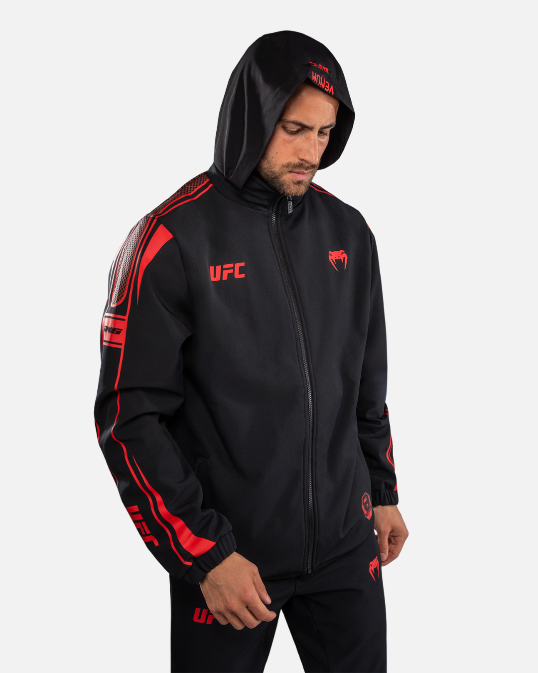 Veste UFC Venum à capuche noire en tissu lisse, avec fermeture zippée et motifs graphiques rouges sur les manches.