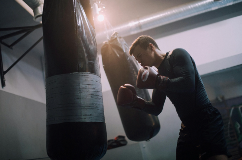 Boxeur qui s'entraine sur un sac de frappe suspendu