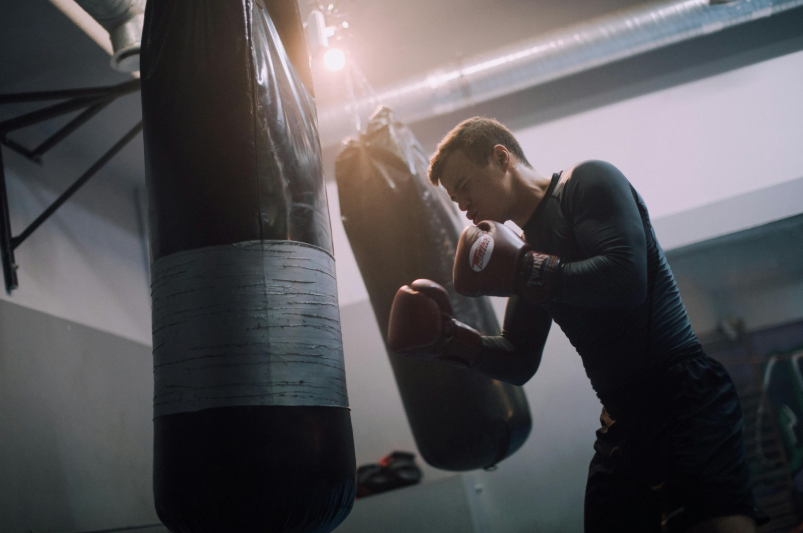 Boxeur qui s'entraine sur un sac de frappe suspendu