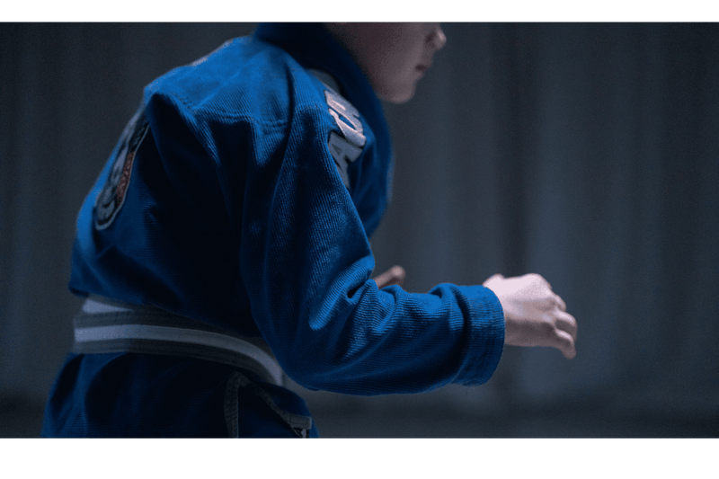 Kimono de JJB bleu porté par un pratiquant de jiu-jitsu brésilien en pleine action