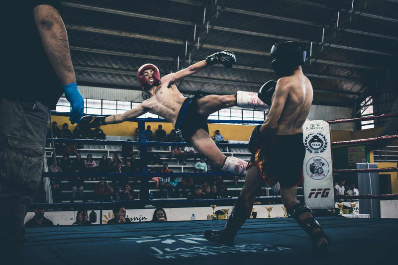 combat de muay thai sur un ring avec des protections