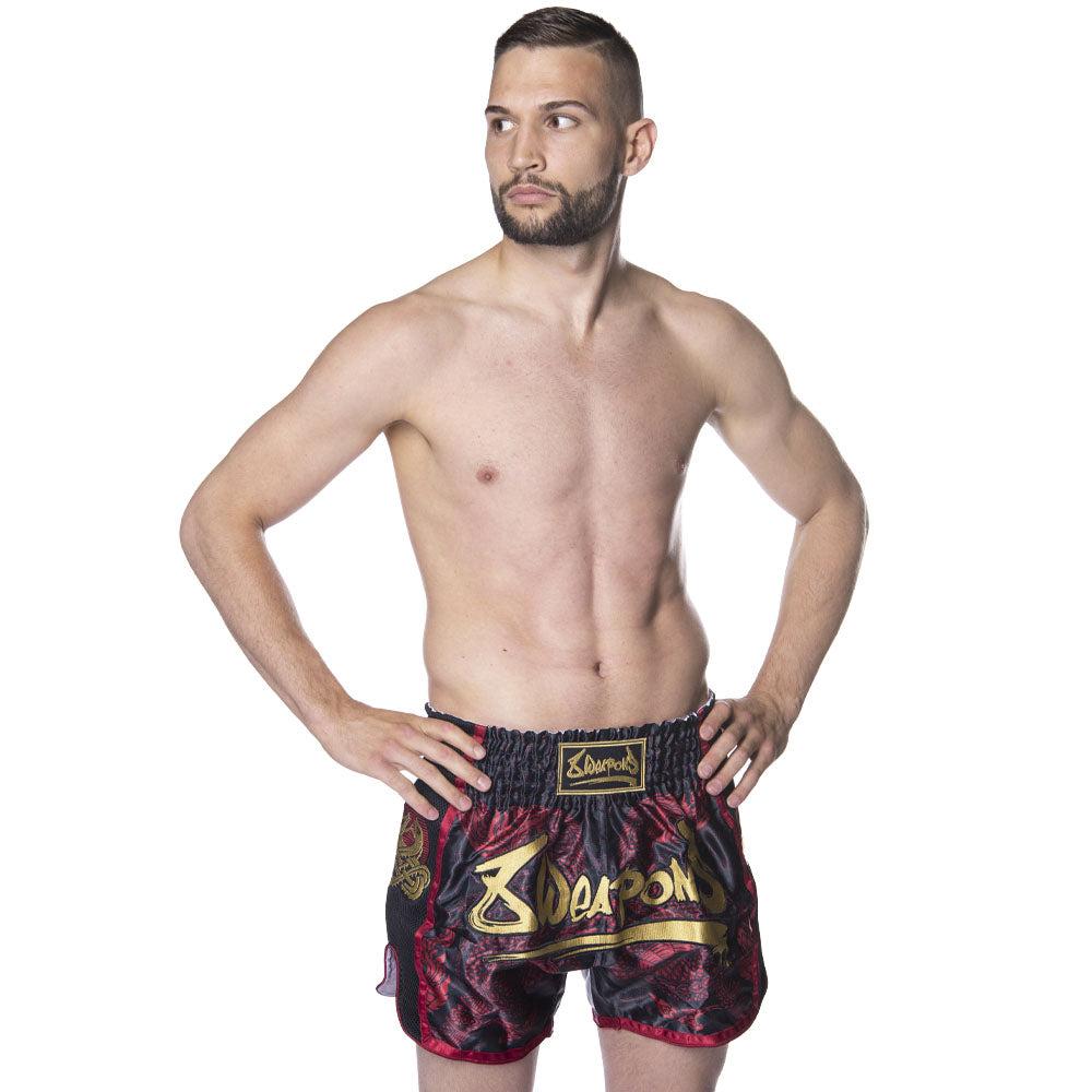 Short de Muay Thaï noir et rouge avec motif Sak Yant Naga, confortable et résistant pour entraînement et combat.