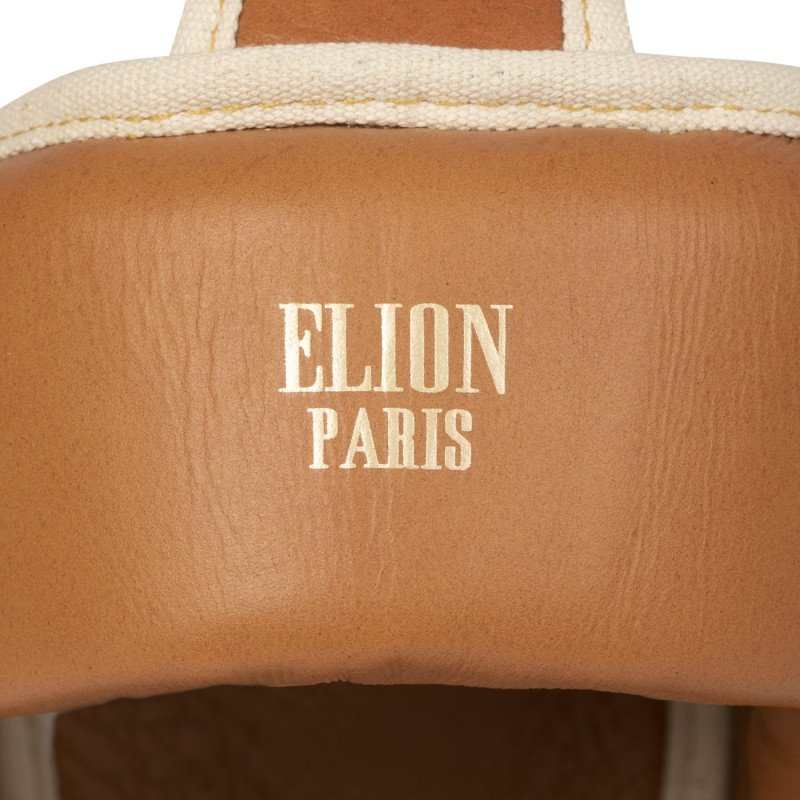 Close-up of brown leather Casque de Boxe Elion Paris boxing headgear with white stitching and logo.