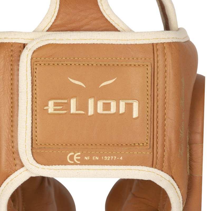 Close-up of tan leather Casque de Boxe Elion boxing headgear showing branded stitching and vintage finish