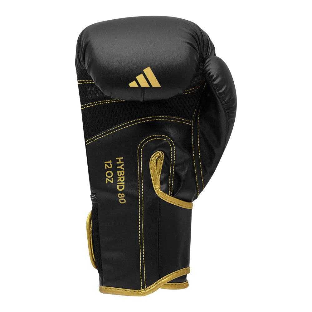 Black and gold Adidas Hybrid 80 boxing glove with durable PU material and secure Velcro closure, designed for optimal shock absorption and wrist support.