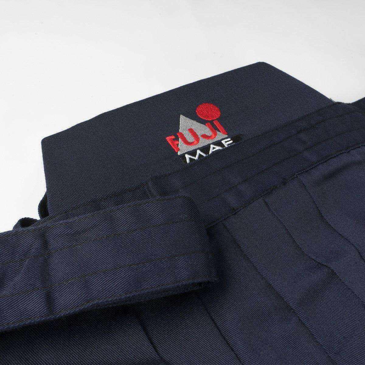 Hakama Training FUJIMAE bleu pour Aïkido, Iaïdo et Kendo, tissu mélangé polyester coton, pli classique et logo brodé.