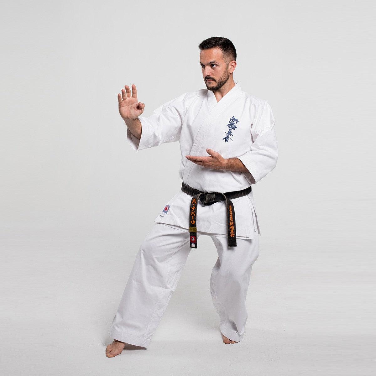 Man practicing karate wearing a traditional Shinkyokushin Yantsu Karate Gi with black belt in a martial arts pose against a plain background