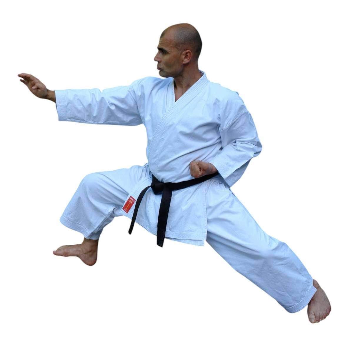 Man practicing karate wearing white Kimono Karate Kamikaze Europa with black belt, demonstrating high kick and stance
