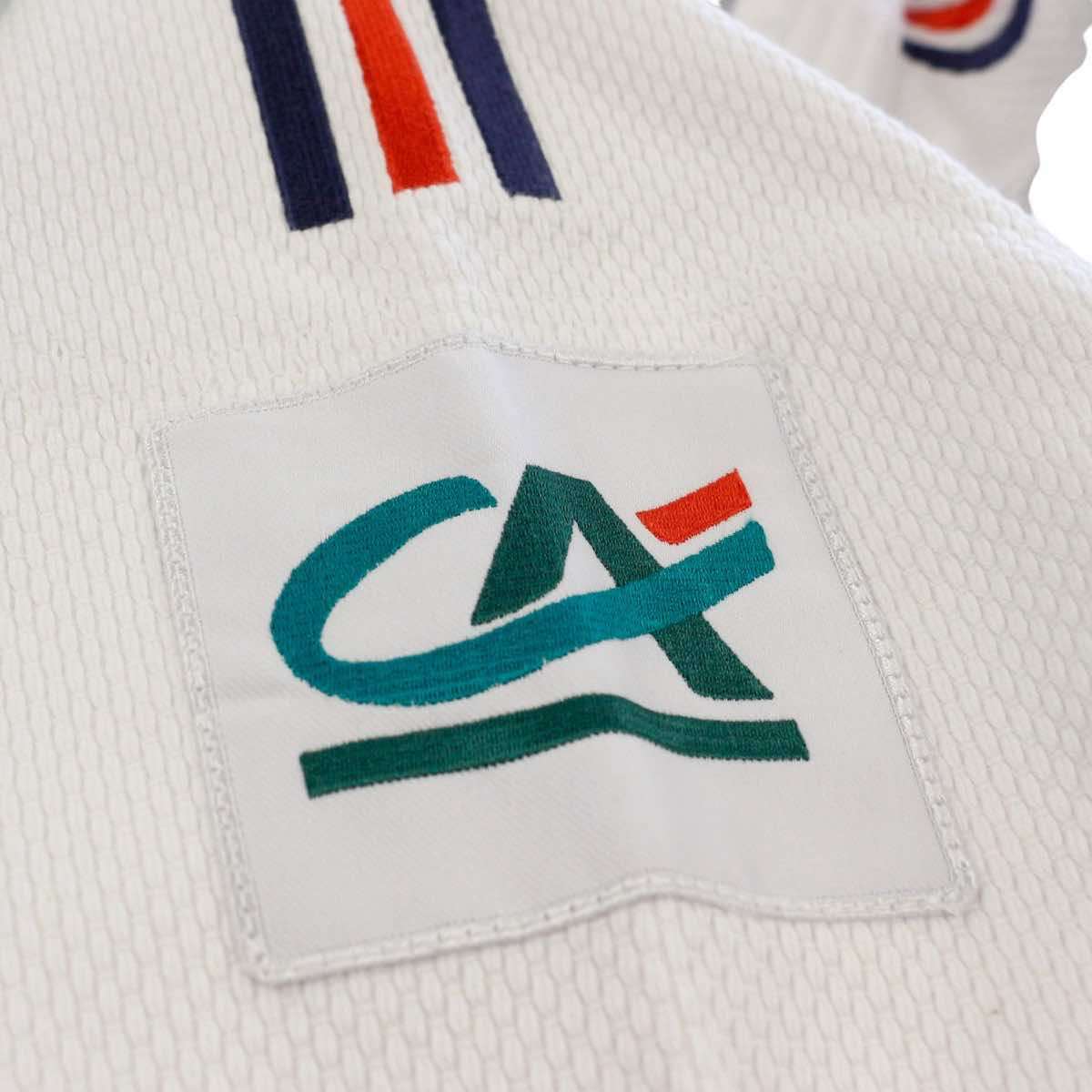 Logo Crédit Agricole brodé sur kimono de judo Adidas Replica Équipe de France blanc en tissu grain de riz robuste