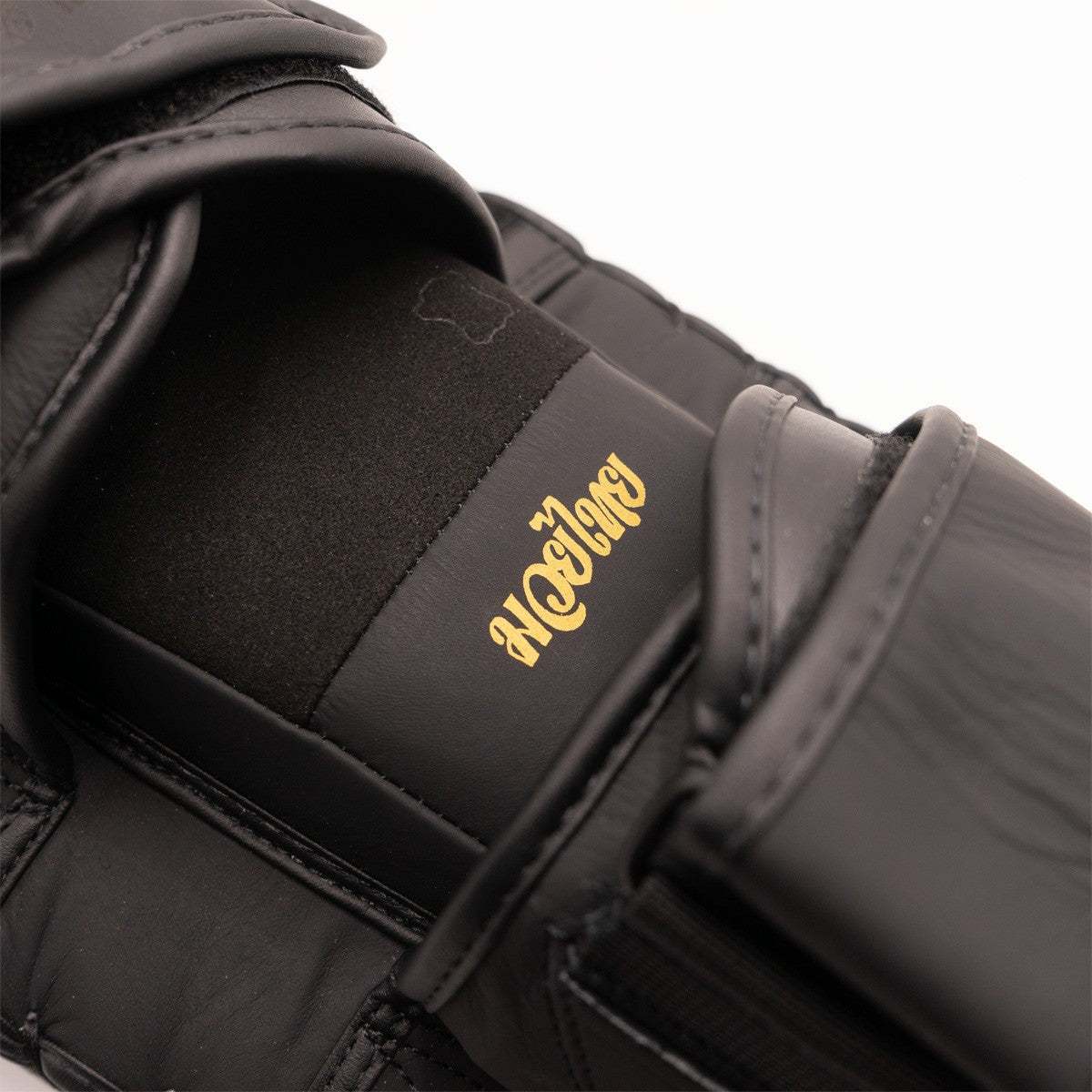 Pao de boxe thaï noir et or en cuir FUJIMAE SakYant II avec design sacré et protection optimale