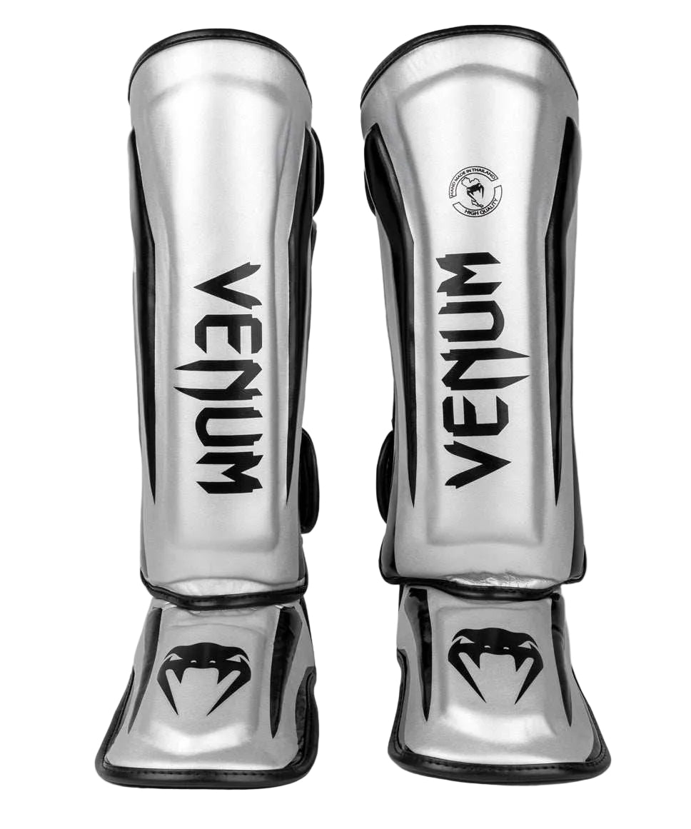 Protège-tibias Venum Elite argent et noir en Skintex haute qualité pour protection et confort optimal en Muay Thaï et kickboxing