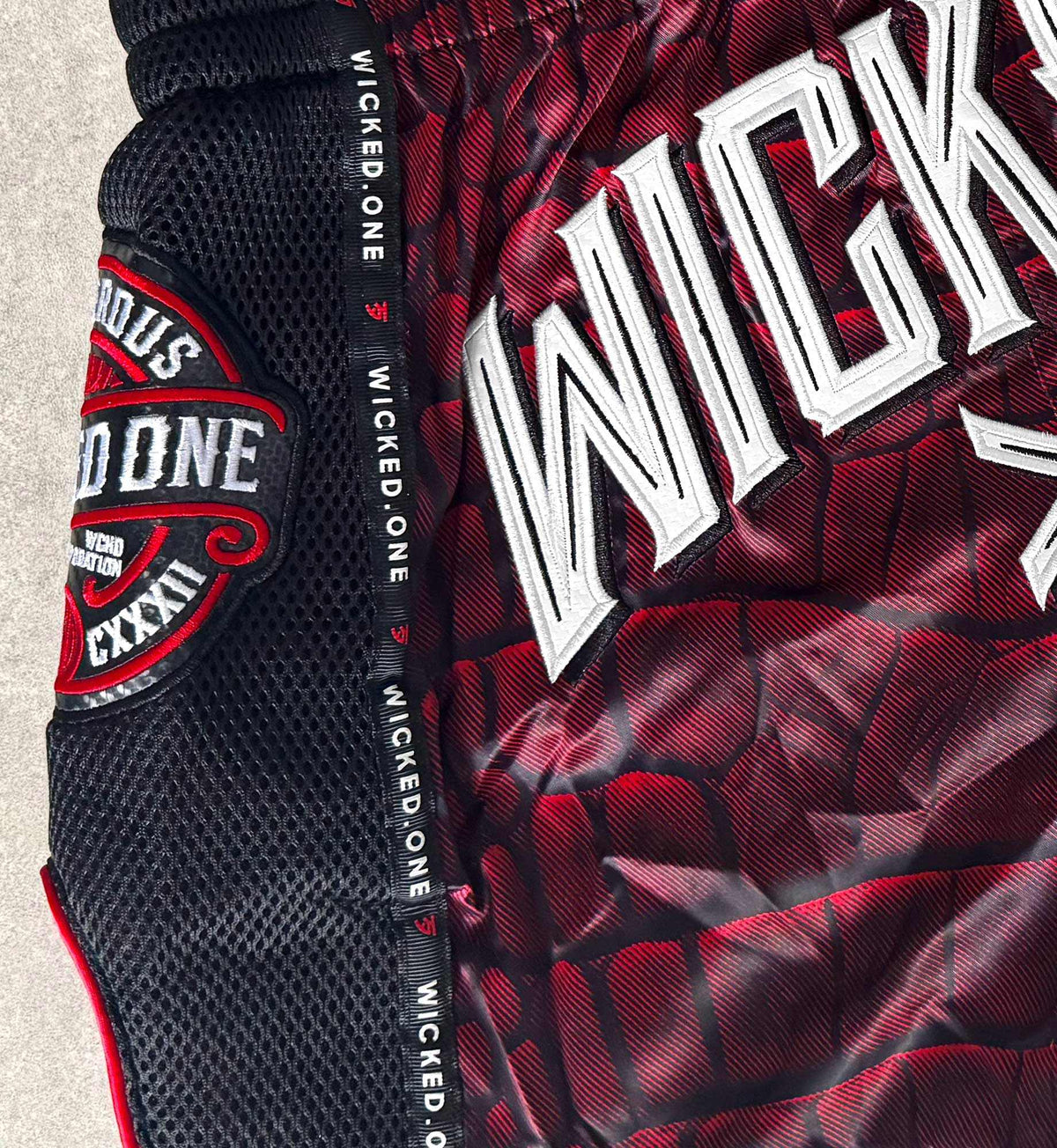 Short de Muay Thaï rouge Wicked One CAÏMAN, coupe traditionnelle avec fentes latérales pour liberté de mouvement