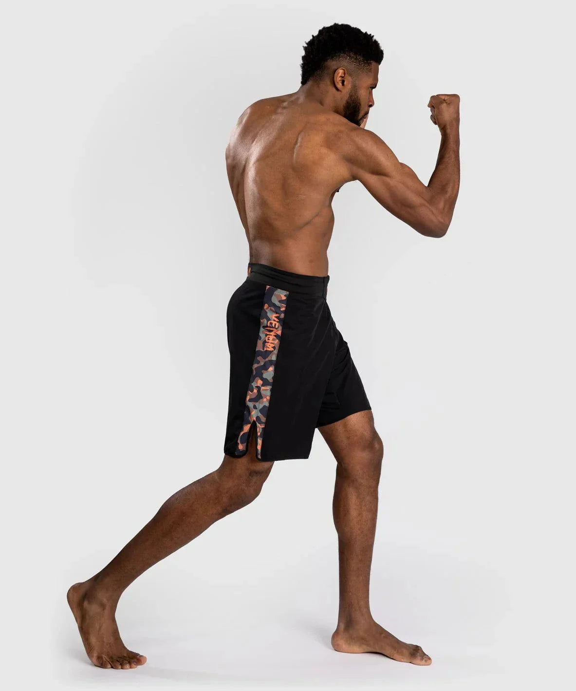 Male athlete wearing black Fightshort Venum Jungle Ops with kakhi camo side panels, posing in a fighting stance