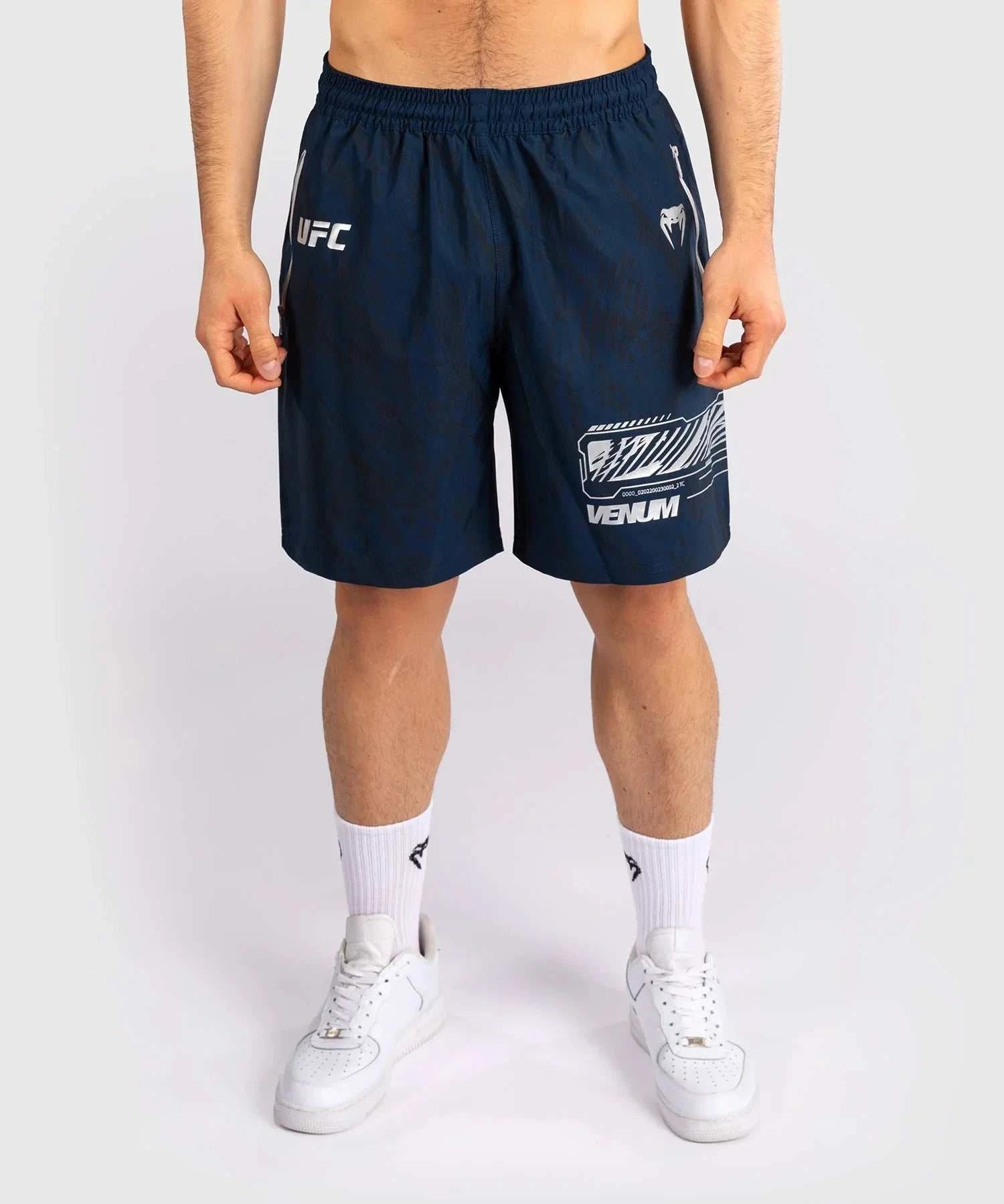 Men wearing navy blue UFC Fusion par Venum performance shorts with elastic waistband and branded logos.