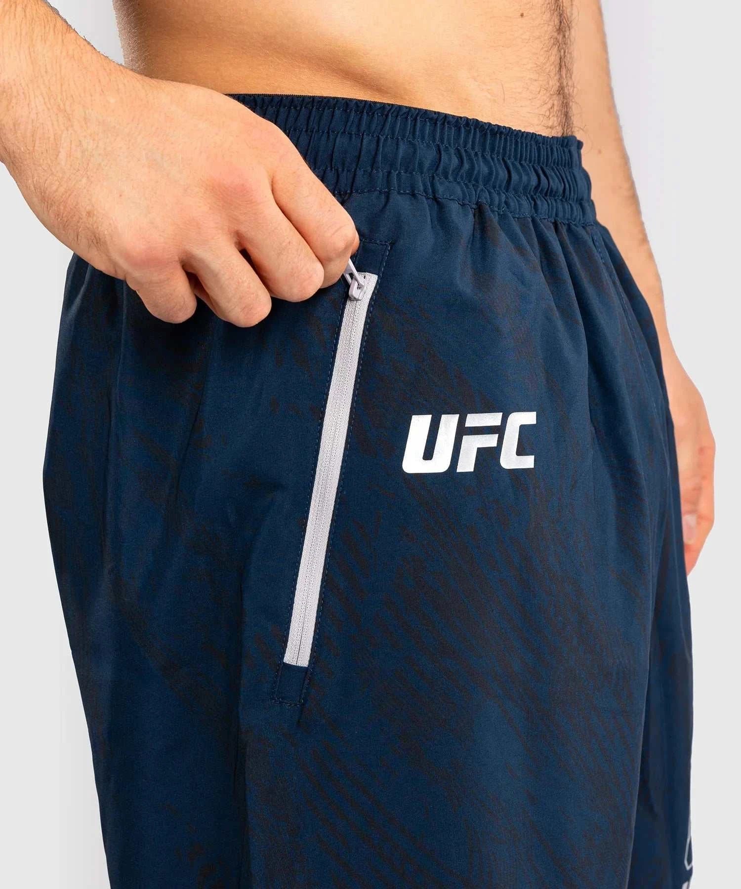 Close-up of navy blue UFC Fusion by Venum performance shorts with elastic waistband and zippered pocket, designed for flexibility and comfort during training.