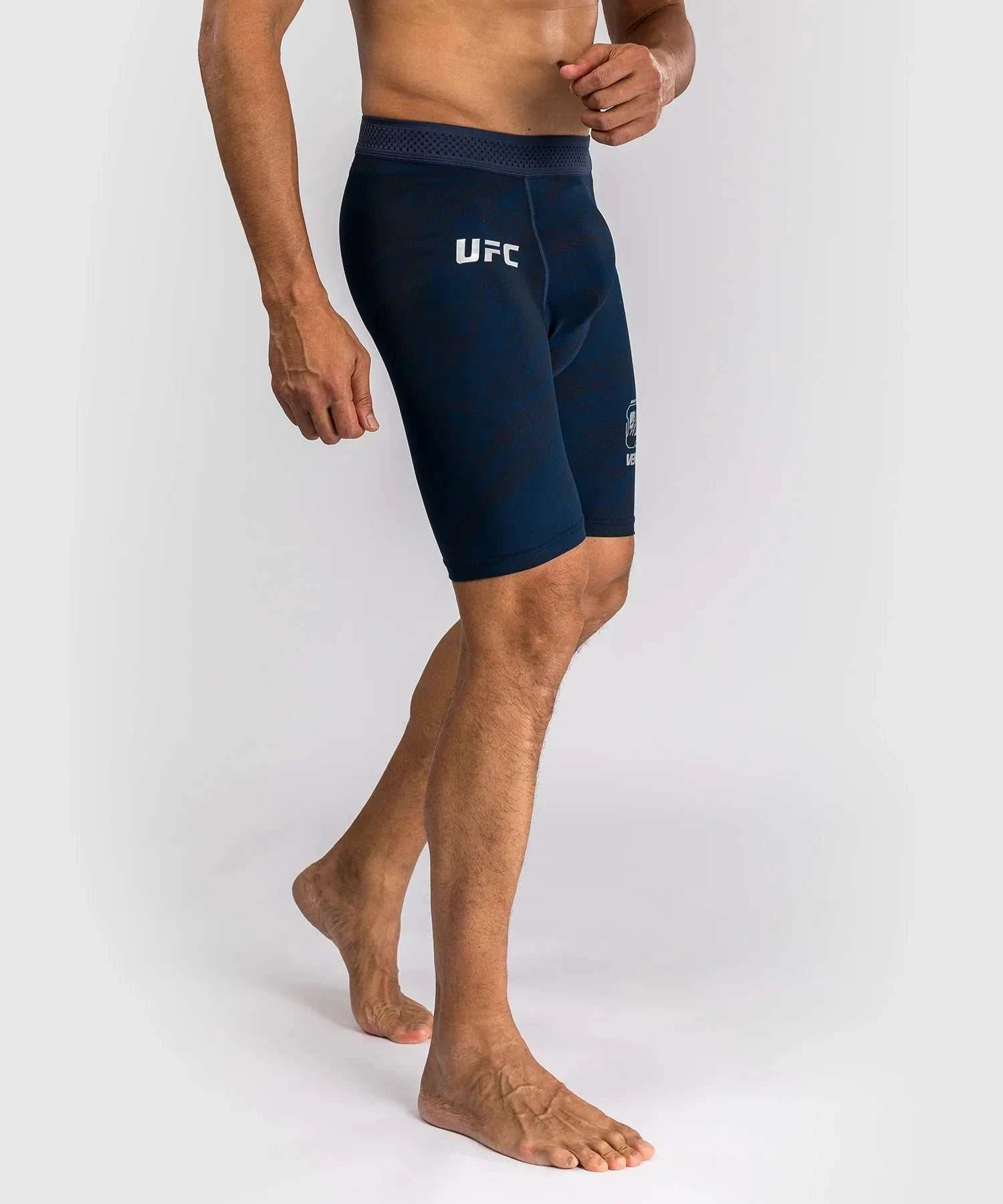 Men wearing navy blue UFC Fusion par Venum compression shorts for high-performance training and MMA fighting.