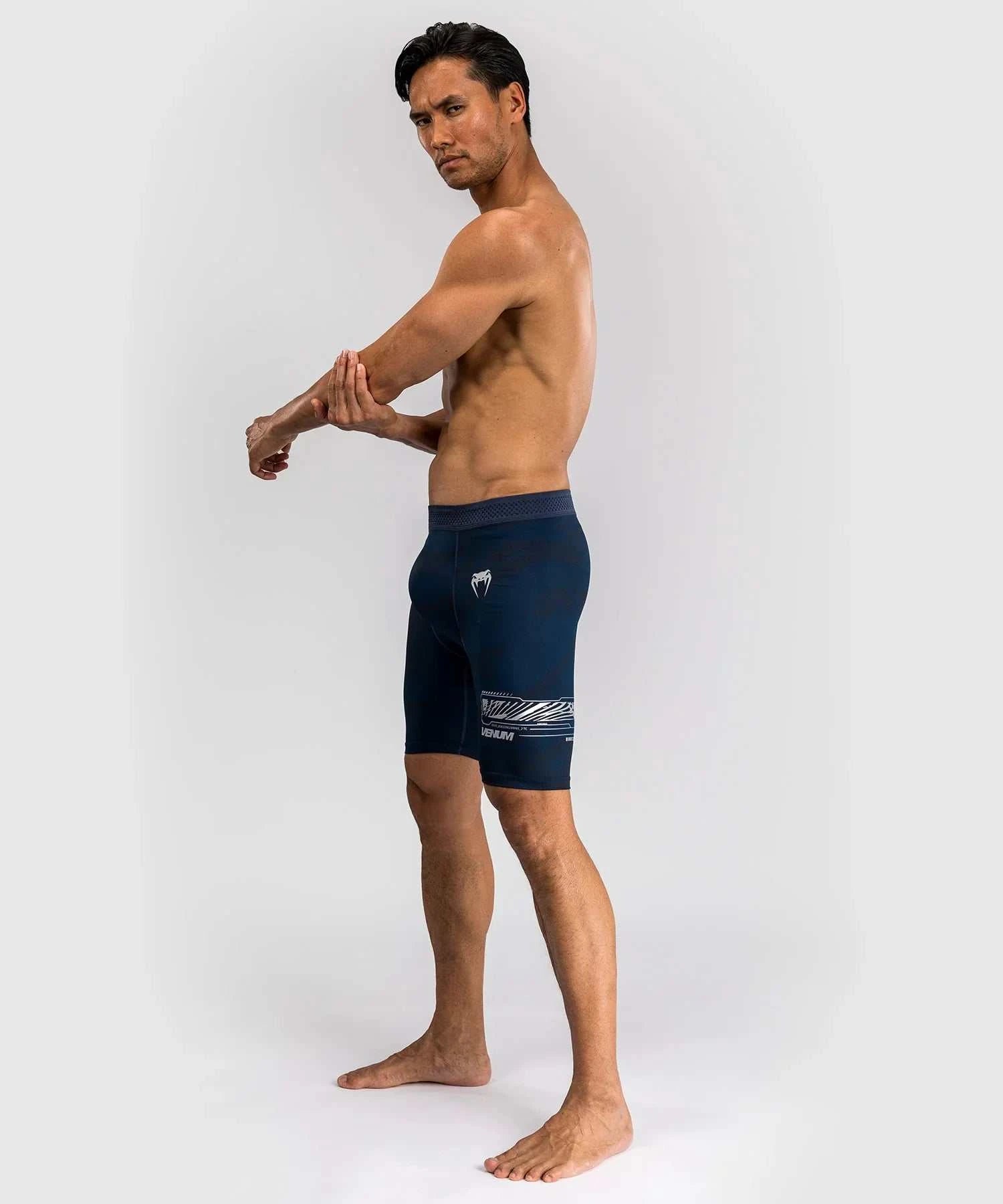 Athlete wearing navy blue UFC Fusion par Venum compression shorts with elastic waistband and elemental design details