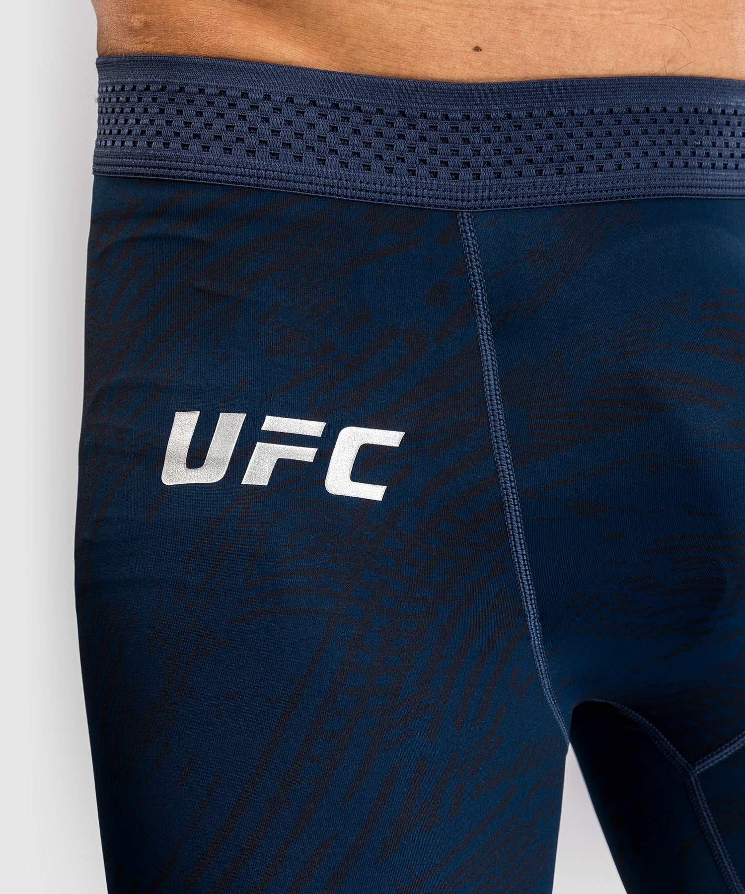 close-up of navy blue UFC Fusion par Venum Vale Tudo shorts with elastic waistband and UFC logo