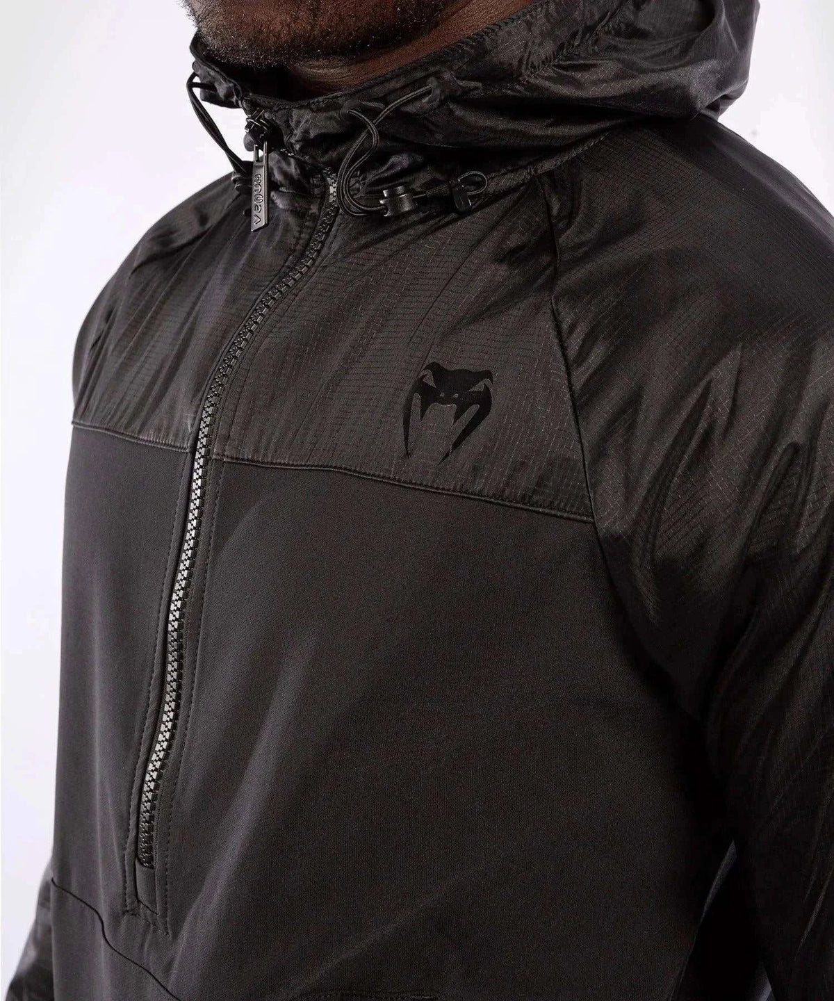 Black Venum Laser XT hooded sweatshirt with adjustable hood and front zipper, featuring printed graphics and water-resistant fabric.