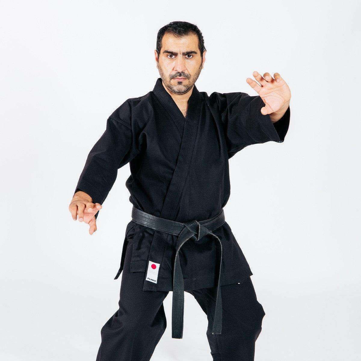 Man practicing karate wearing black Veste de Karaté-gi Legacy II with black belt