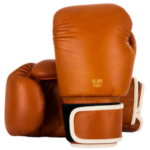Gants de boxe ELION marron en cuir de vache, mousse triple densité, forme ronde compacte sans renfort de paume, couture renforcée, fermeture velcro, fabrication thaïlandaise.