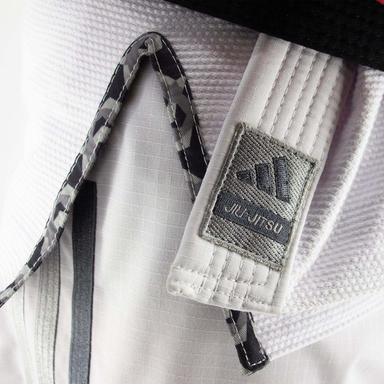Kimono de JJB Adidas Contest 2.0 blanc avec logo brodé, détail intérieur camo et tissu ripstop renforcé.