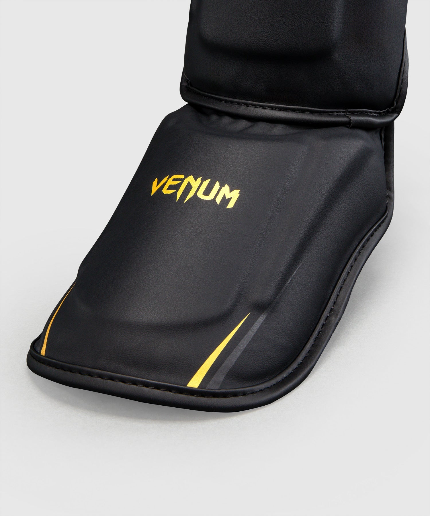 Protège-tibias Venum G-Core Noir/Or disponible à la Boutique des Arts Martiaux