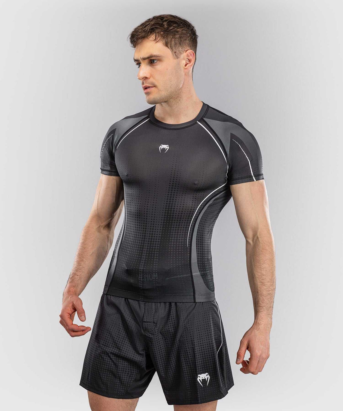 Rashguard manches courtes Venum Stealth noir et blanc pour MMA et JJB avec tissu extensible et bande silicone à la taille