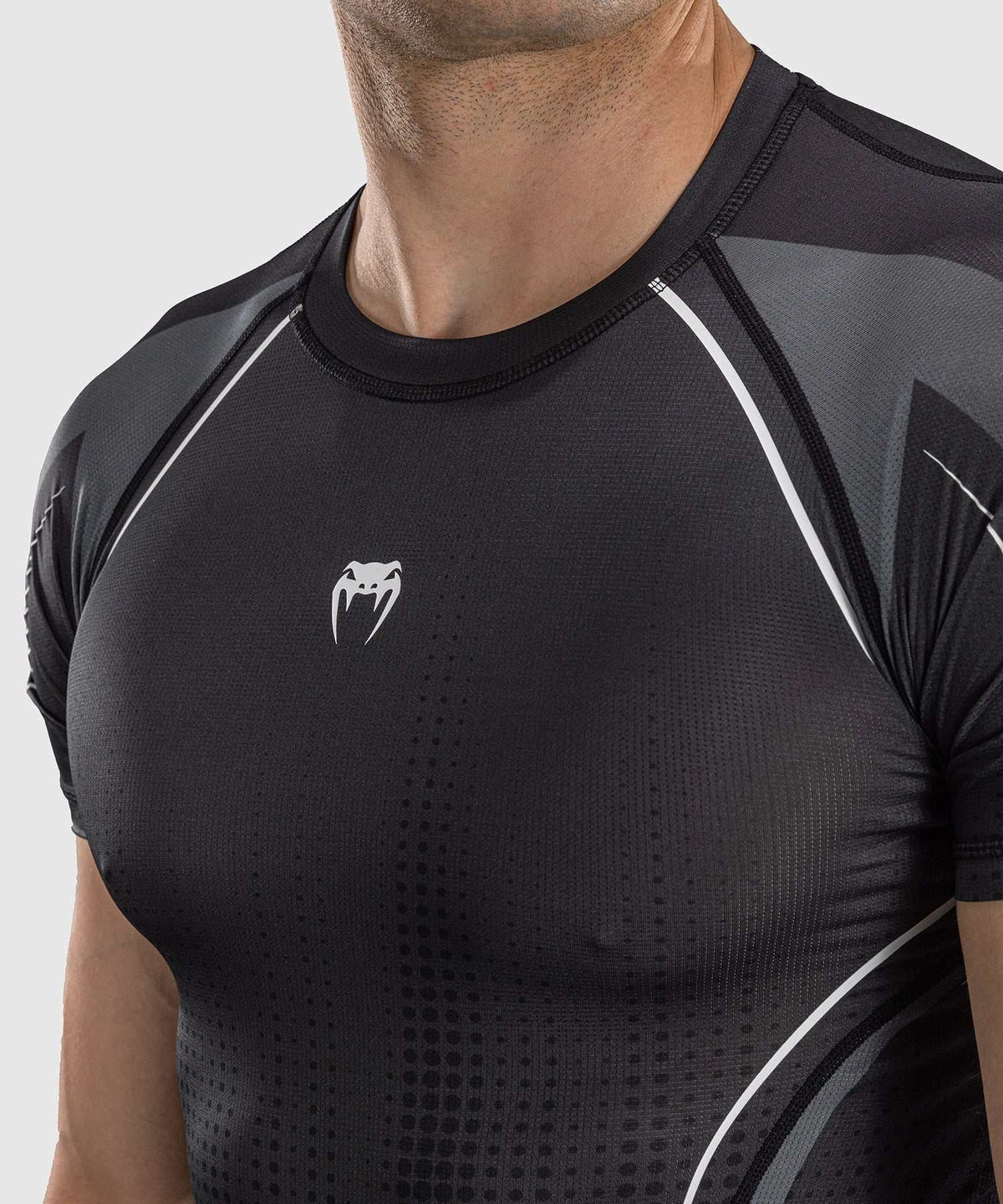 Rashguard manches courtes Venum Stealth noir blanc pour MMA et sports de combat, coupe compressive et tissu extensible.