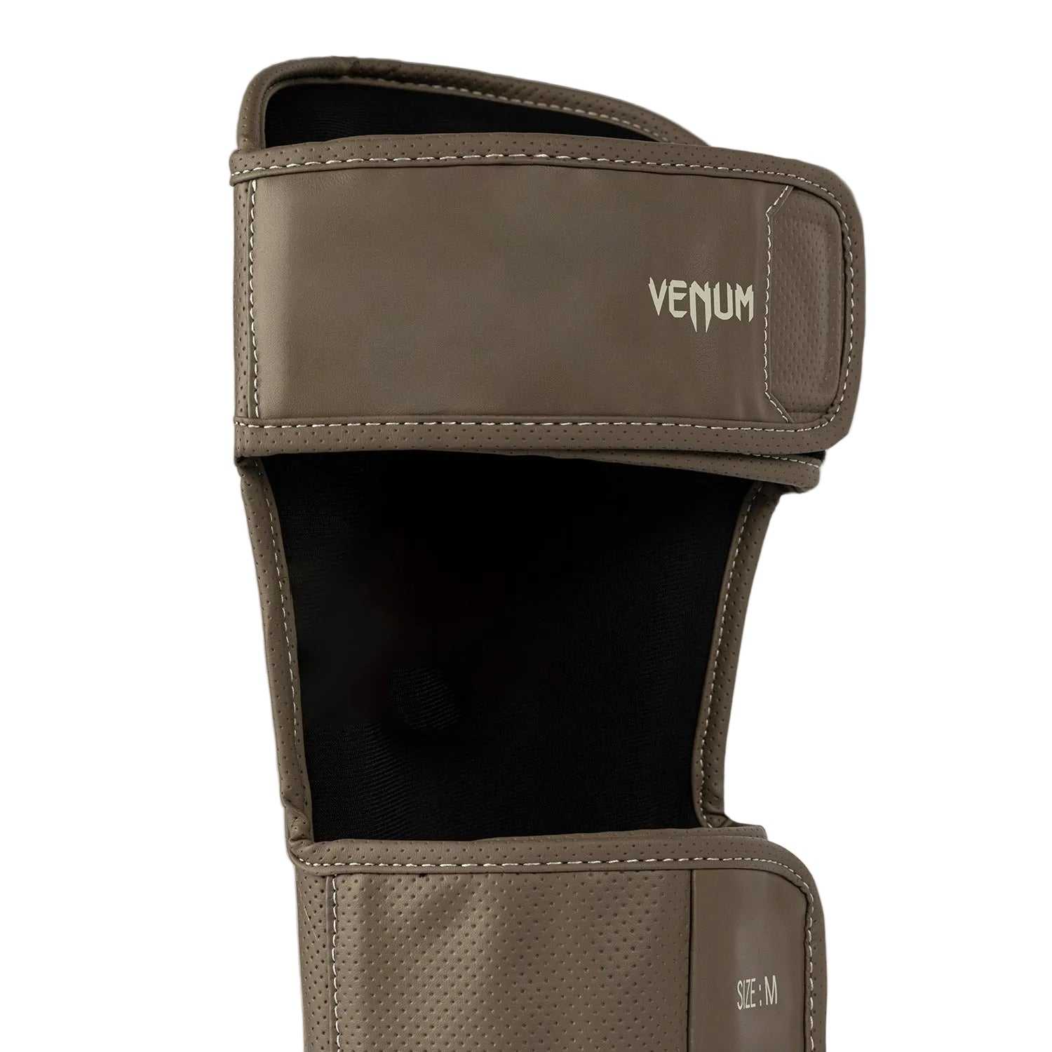 Protège-tibias Venum Impact Evo Scales marron en cuir Skintex premium pour kickboxing, boxe thaï et MMA, avec mousse multi-densités et maintien velcro.