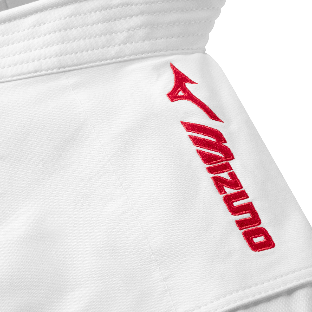 Close-up of white Mizuno karate kimono jacket with red embroidered logo on shoulder, designed for kata competitions.